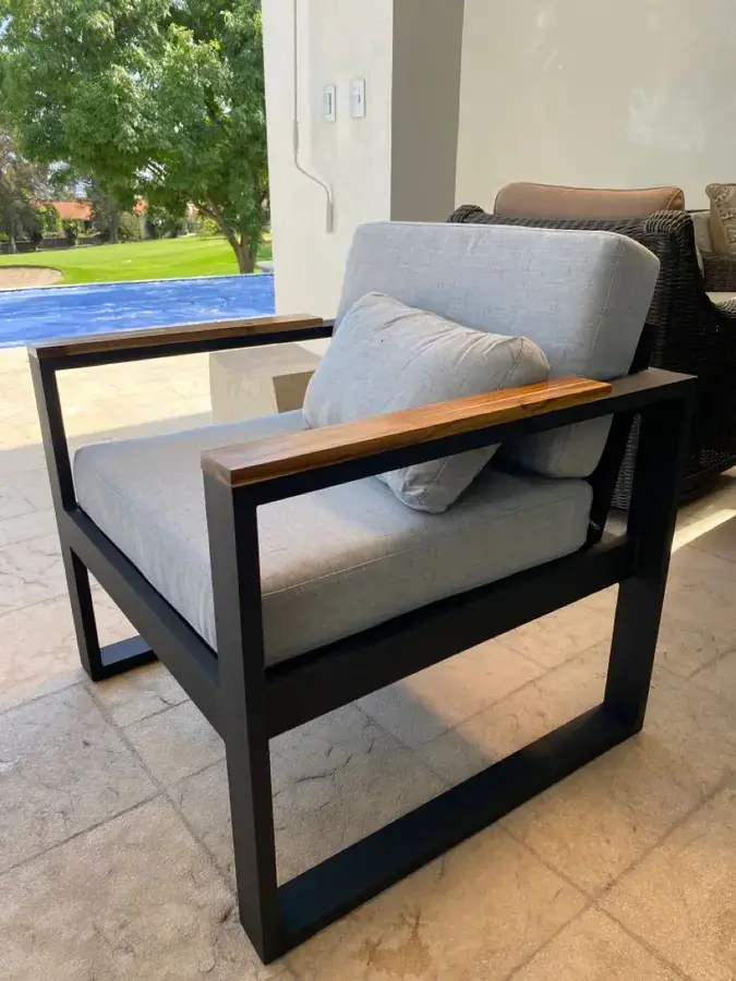 Black steel patio lounge chair with wooden armrests